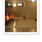 Vy över en yogastudio med femton mattor på golvet, lampor och fönster på väggarna.