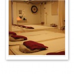 Bild från yogastudion, med vita mattor på golvet och gonggongen i bakgrunden.