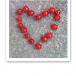 Ett hjärta på en stenplatta, skapat av röda vinbär.
